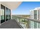 Spacious condo balcony with glass railings, overlooking city views on a clear day, featuring modern architectural style at 231 Riverside Dr # 2310, Holly Hill, FL 32117