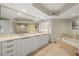 A luxurious bathroom featuring a double vanity, soaking tub, and a glass-enclosed shower at 231 Riverside Dr # 2310, Holly Hill, FL 32117
