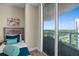 A charming bedroom with a cozy bed and sliding glass doors to a balcony with city views at 231 Riverside Dr # 2310, Holly Hill, FL 32117