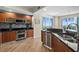 Well-lit kitchen featuring wood cabinets, stainless appliances, black countertop and a large window at 231 Riverside Dr # 2310, Holly Hill, FL 32117