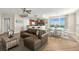 Open-concept living area with sleek furniture, wood floors, a modern kitchen, and abundant natural light at 231 Riverside Dr # 2310, Holly Hill, FL 32117