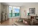 Well-lit living room with chic decor, wood-style flooring, and sliding glass doors with beautiful views at 231 Riverside Dr # 2310, Holly Hill, FL 32117