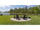 Backyard fire pit with Adirondack chairs overlooking a serene lake at 258 Sandoval Dr, Ormond Beach, FL 32174