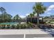 Community pool and pool house are framed by a black metal fence and palm trees at 258 Sandoval Dr, Ormond Beach, FL 32174