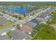 Sprawling aerial view of houses with green spaces, a serene lake and neatly paved roads in a neighborhood at 2672 Star Coral Ln, New Smyrna Beach, FL 32168