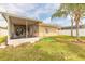 Expansive backyard featuring green lawn, partial fence, palm tree, and screened lanai at 2672 Star Coral Ln, New Smyrna Beach, FL 32168