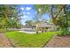 Beautiful backyard with a pool, lush green lawn, and a charming yellow house at 28 Shadowcreek Way, Ormond Beach, FL 32174