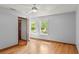 Bright bedroom with wood floors, a ceiling fan, and two windows overlooking a lush yard at 28 Shadowcreek Way, Ormond Beach, FL 32174
