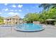Large community pool with ample seating and a two-story clubhouse in the background at 28 Shadowcreek Way, Ormond Beach, FL 32174