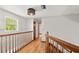 Second floor hallway with wood floors and wooden railing at 28 Shadowcreek Way, Ormond Beach, FL 32174