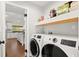Laundry room with modern washer and dryer, shelving, and a view into the kitchen at 28 Shadowcreek Way, Ormond Beach, FL 32174