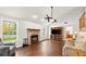 Cozy living room with a brick fireplace, a large window, and wood-look tile floors at 28 Shadowcreek Way, Ormond Beach, FL 32174