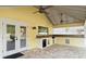 A cozy outdoor kitchen offers a sink, mini fridge, and stone countertops at 28 Shadowcreek Way, Ormond Beach, FL 32174