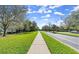 Scenic street view with lush green lawns and a paved sidewalk offering a pleasant neighborhood experience at 28 Shadowcreek Way, Ormond Beach, FL 32174