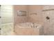Bathroom featuring large soaking tub, tile backsplash, and walk-in closet at 2811 S Asciano Ct, New Smyrna Beach, FL 32168