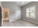Well-lit bedroom featuring wood-style tile flooring, neutral paint, and closet with bi-fold doors, and backyard views at 2811 S Asciano Ct, New Smyrna Beach, FL 32168