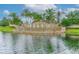 Community entrance showcasing a picturesque water feature surrounded by lush landscaping and palm trees at 2811 S Asciano Ct, New Smyrna Beach, FL 32168