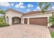 Exterior with a brick driveway and a two-car garage, showcasing the home's architectural details at 2811 S Asciano Ct, New Smyrna Beach, FL 32168