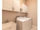 Clean laundry room with washer, dryer, white cabinets, and a utility sink for extra convenience at 2811 S Asciano Ct, New Smyrna Beach, FL 32168