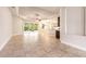 Spacious living area featuring tile flooring, a tray ceiling, and an open layout to the kitchen and outdoor space at 2811 S Asciano Ct, New Smyrna Beach, FL 32168
