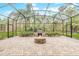 Relaxing screened-in patio with brick flooring, cozy firepit, outdoor kitchen, and peaceful backyard views at 2811 S Asciano Ct, New Smyrna Beach, FL 32168