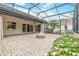 Relaxing screened-in patio with brick flooring, cozy firepit, outdoor kitchen, and views of manicured backyard at 2811 S Asciano Ct, New Smyrna Beach, FL 32168