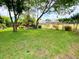 Large grassy backyard enclosed by a chain-link fence with mature trees providing shade and privacy at 2953 Autumn Run Pl, Orlando, FL 32822