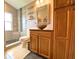 Bathroom featuring wood cabinets, a vessel sink, decorative mirror, and glass-enclosed shower at 2953 Autumn Run Pl, Orlando, FL 32822