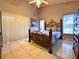 Bright bedroom featuring a decorative metal bed frame, neutral color walls, and tile floors at 2953 Autumn Run Pl, Orlando, FL 32822