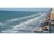 Beautiful oceanfront view of the sandy beach along the coastline with high rise buildings in the distance at 2967 S Atlantic Ave # 1404, Daytona Beach, FL 32118
