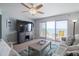 Comfortable living room featuring sofas, a television, and a sliding glass door to the ocean view at 2967 S Atlantic Ave # 1404, Daytona Beach, FL 32118