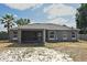 Back exterior view showing a screened lanai and lush yard with a new roof at 3025 Bonkirk Dr, Deltona, FL 32738