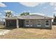 Rear exterior showcasing the property's screened porch, neutral paint, and landscaped yard at 3025 Bonkirk Dr, Deltona, FL 32738