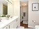Well-lit bathroom featuring double sinks, white countertops, wood floors, and a framed art piece at 3025 Bonkirk Dr, Deltona, FL 32738