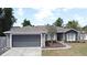 Charming single-story home with a two-car garage, manicured lawn and neutral-colored paint scheme at 3025 Bonkirk Dr, Deltona, FL 32738