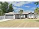 Charming single-story home with a two-car garage, landscaped yard, and gray stucco exterior at 3025 Bonkirk Dr, Deltona, FL 32738
