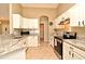 Well-lit kitchen featuring white cabinets, granite countertops, and stainless steel appliances at 3025 Bonkirk Dr, Deltona, FL 32738