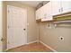 Bright laundry room featuring overhead cabinets, tile floors, and utility connections at 3025 Bonkirk Dr, Deltona, FL 32738
