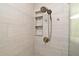 Walk in shower with a dual shower head, neutral tile, and a built in shelving unit at 3025 Bonkirk Dr, Deltona, FL 32738