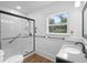 Bright bathroom with shower, white walls, wood floors, and a window overlooking trees at 333 N Kentucky Ave, Deland, FL 32724