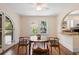 Sunny dining room with an arched doorway, a window, a round table with chairs, and access to the kitchen at 333 N Kentucky Ave, Deland, FL 32724