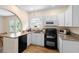 Bright kitchen featuring white cabinets, granite countertops, a black stove, and stainless steel microwave at 333 N Kentucky Ave, Deland, FL 32724