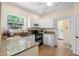 Well-equipped kitchen with granite countertops, modern appliances, and an adjacent laundry area at 333 N Kentucky Ave, Deland, FL 32724