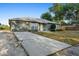 Charming single-story home with long concrete driveway, manicured shrubs, and an attached garage at 333 Redwood Ave, Orange City, FL 32763