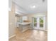 Bright kitchen with white cabinets, breakfast bar, tile backsplash, and sliding door to the outside at 333 Redwood Ave, Orange City, FL 32763