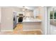 Open-concept kitchen features stainless appliances, white cabinetry, and adjacent sunroom at 333 Redwood Ave, Orange City, FL 32763