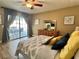 Bright bedroom with access to the patio, wood-look tile floors, dresser, and comfortable bed at 400 Taylorville St, Deltona, FL 32725