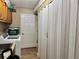 Functional laundry room features a washer, sink, storage cabinets, and folding door at 400 Taylorville St, Deltona, FL 32725