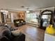 Cozy living room showcasing comfortable seating, a bay window, and neutral tones with wood tile flooring at 400 Taylorville St, Deltona, FL 32725