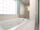 Close up of tile enclosed jacuzzi tub next to window and glass enclosed shower at 41 Ormond Green Blvd, Ormond Beach, FL 32174